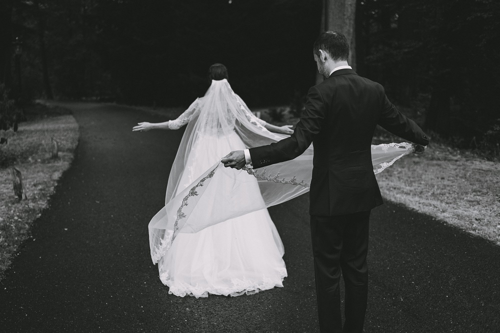 zwart wit trouwfoto met lange bruidssluier